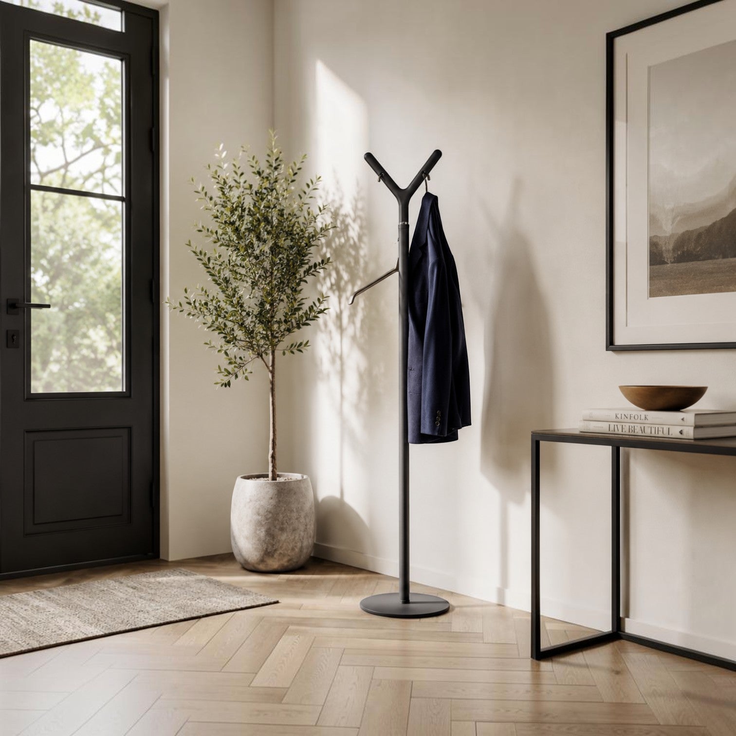 Addo Shop Alfred Coat Stand in matte black with a modern Y-shaped design, holding a navy blue blazer in an entryway.