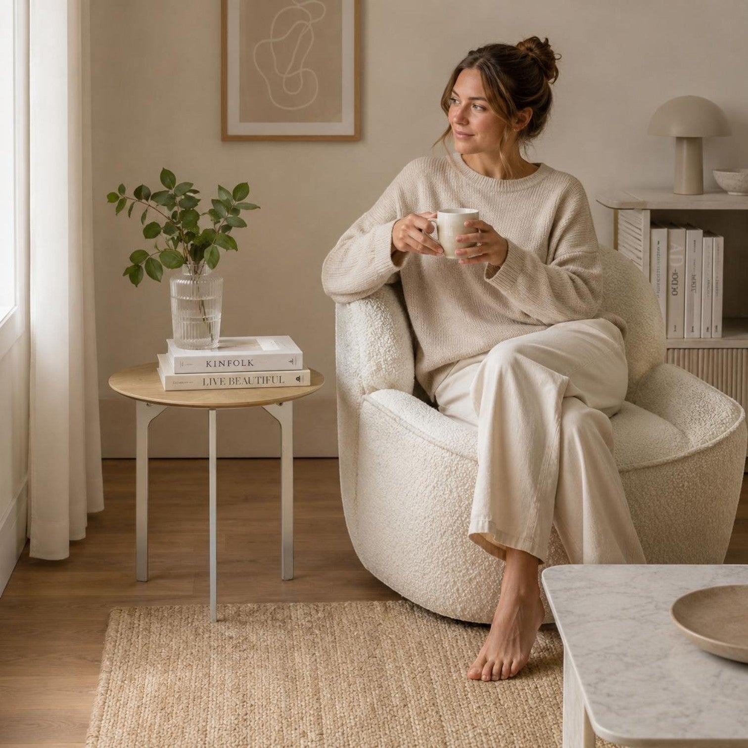 Addo Shop Fly Round Coffee Table with natural wood veneer top and slim metal legs in a cozy modern living room.