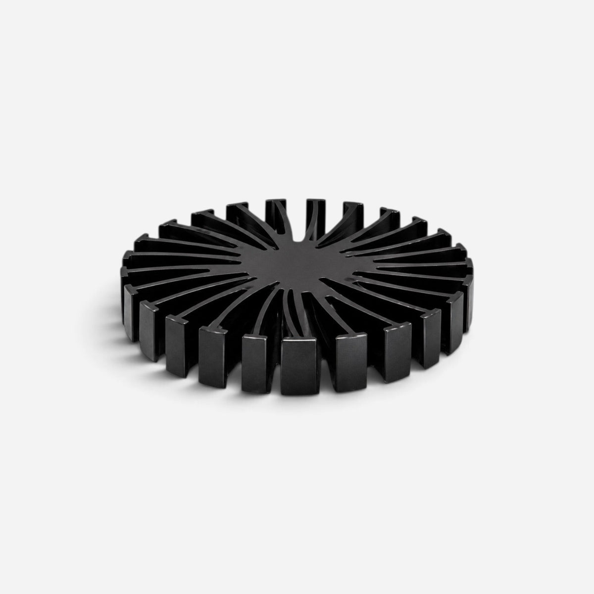 Addo Shop ALT black brushed aluminum trivet with a circular, industrial-inspired radial fin design.