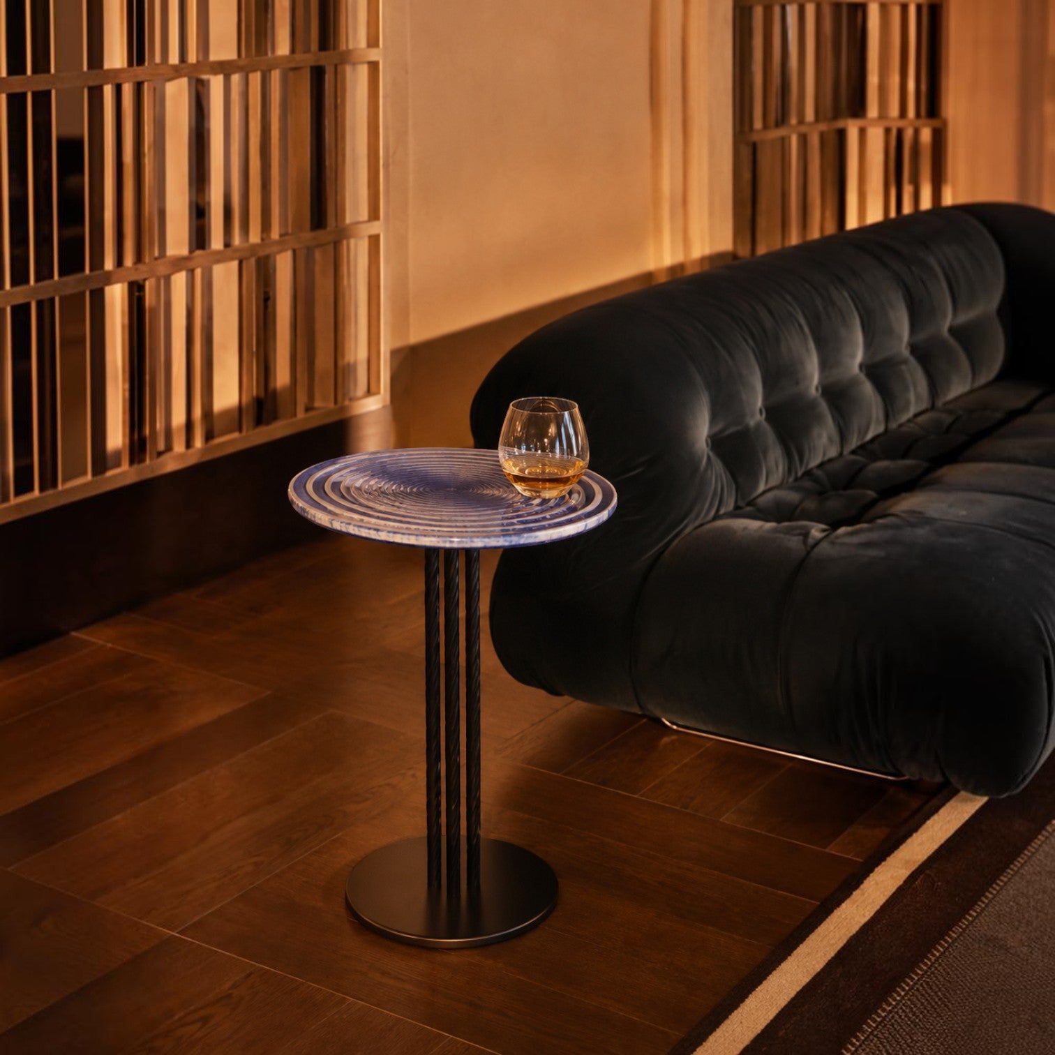 Addo Shop side table with a blue circular patterned top and black metal base next to a dark velvet sofa