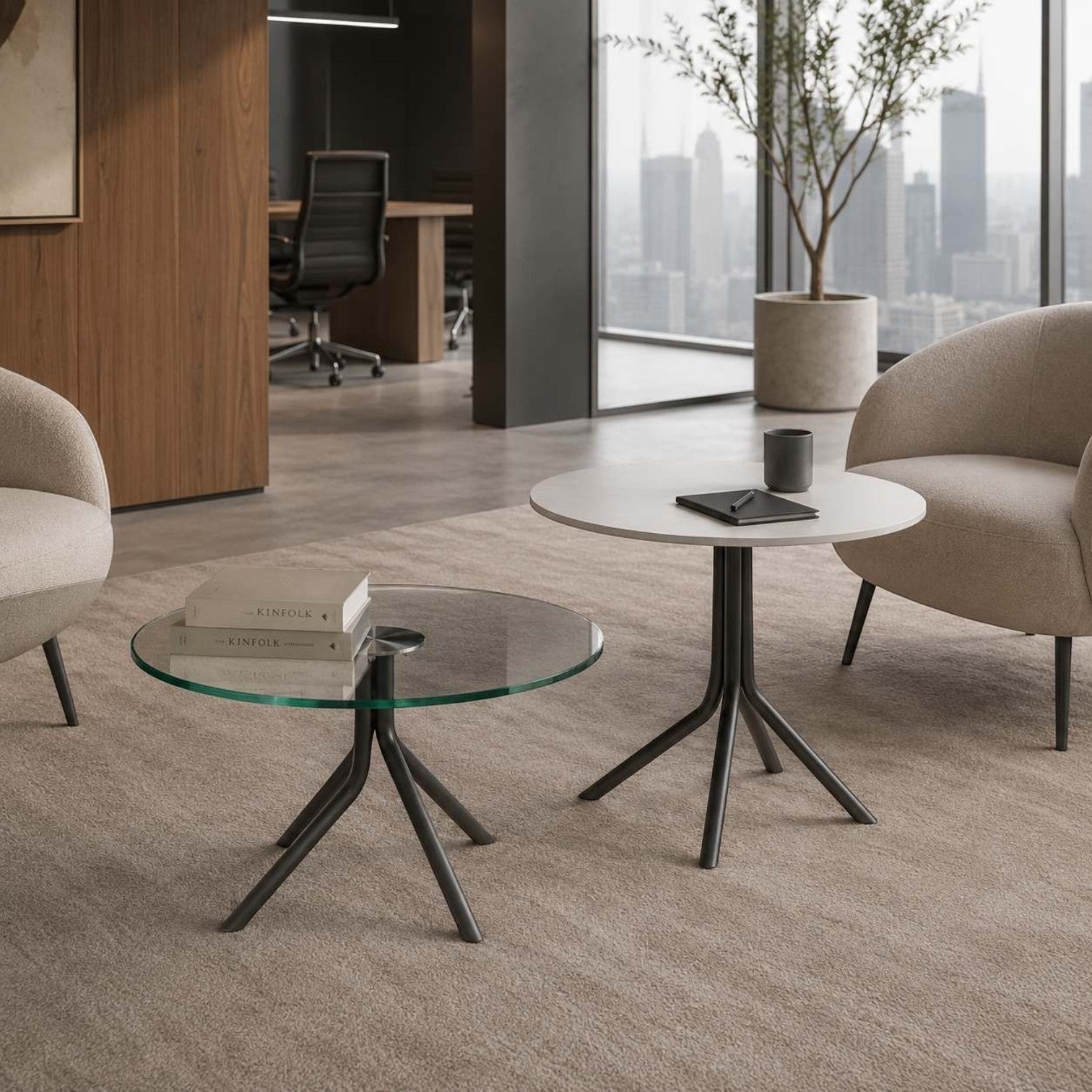 Addo Shop Bob Low round glass coffee table with a black metal base in a modern office lounge setting.