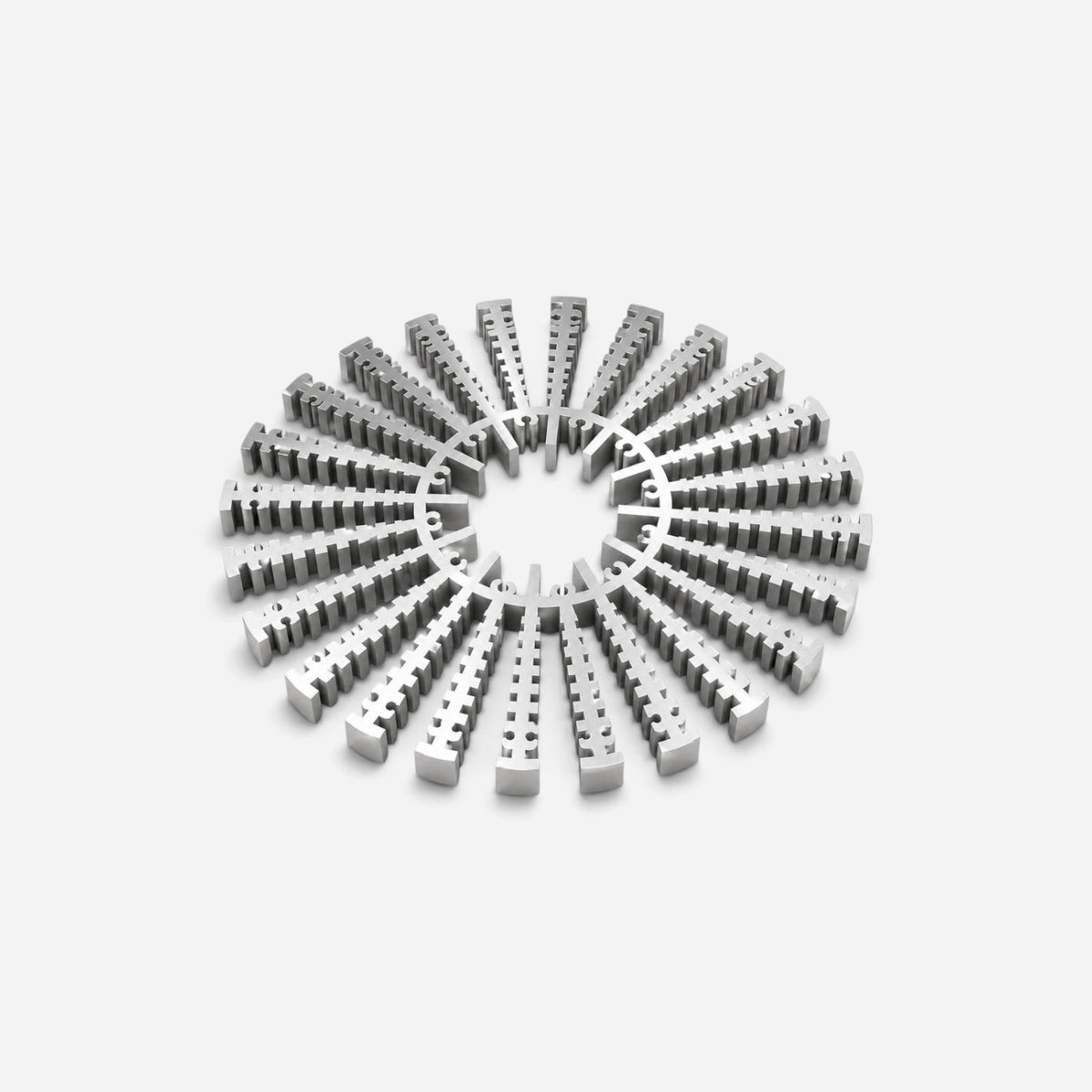 Addo Shop NE-HALE brushed aluminum trivet with a sculptural radial design for heat protection on kitchen surfaces.