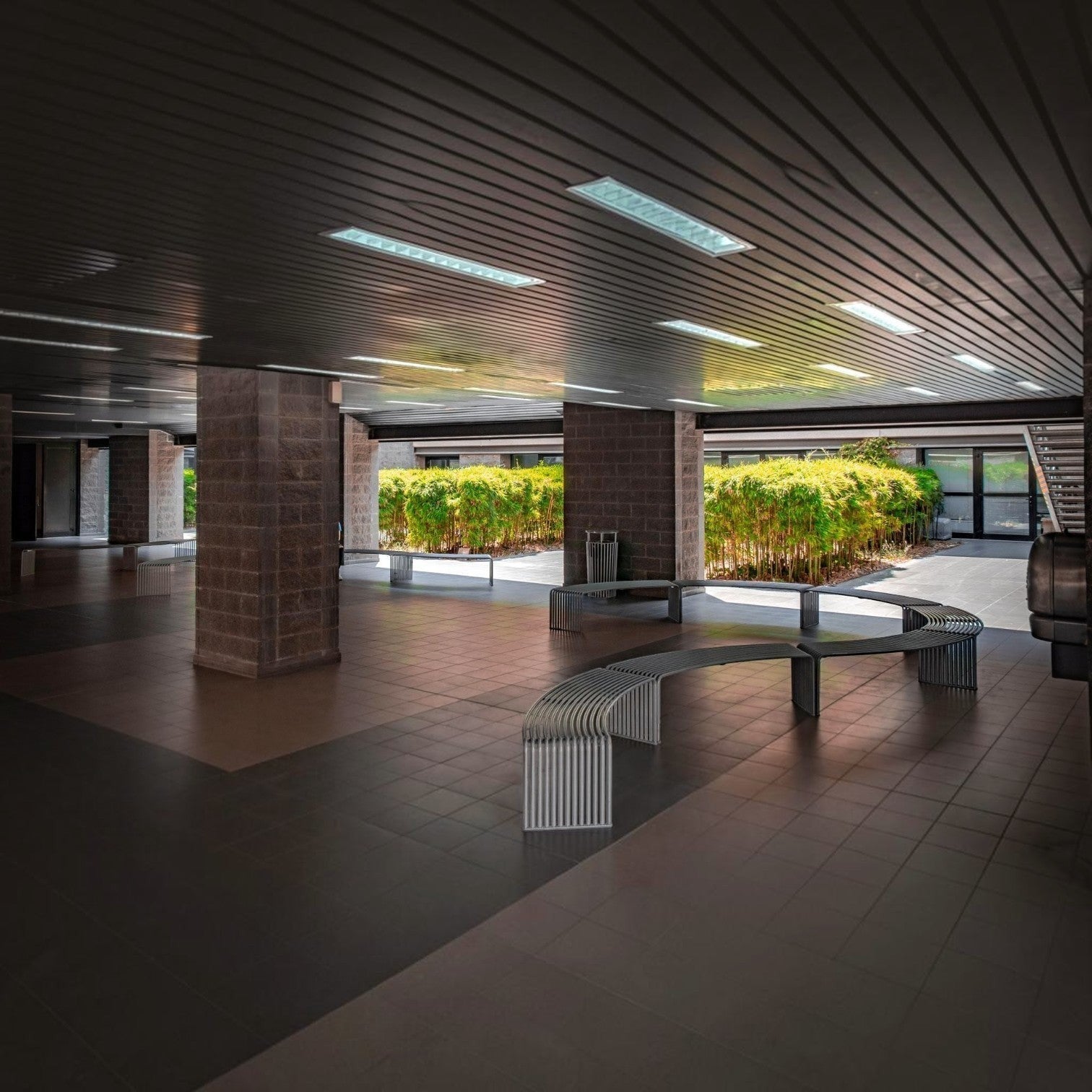 Addo Shop DIEMMEBI .015 concave and convex steel benches in a modern outdoor public courtyard setting.