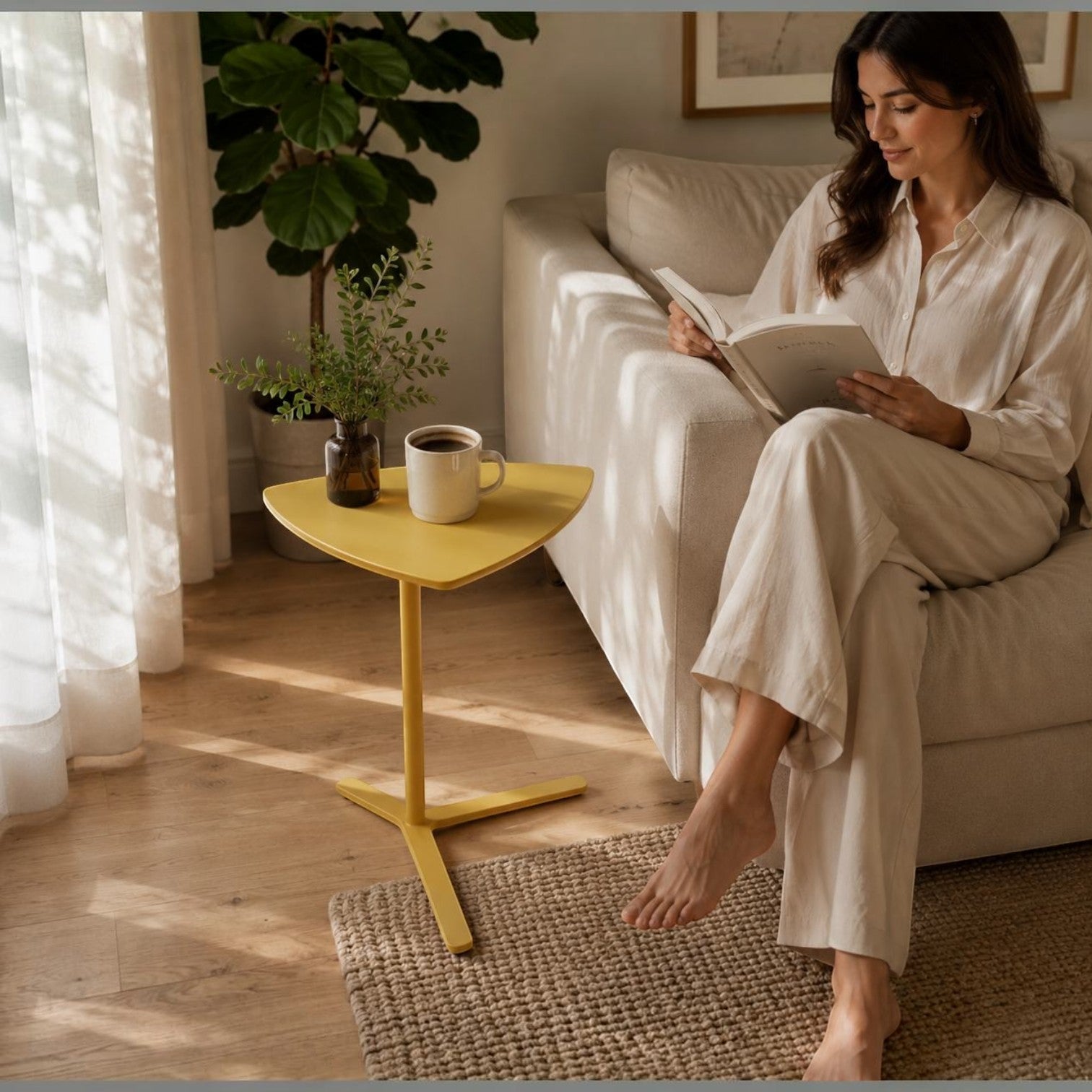 Addo Shop Dodo Triangle Side Table in yellow with a minimalist metal cantilever base next to a sofa in a living room