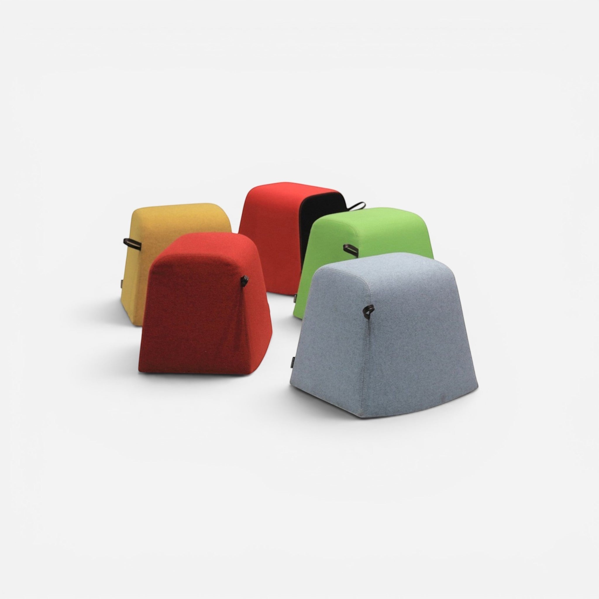 Addo Shop Dondolo pouf in light blue, red, yellow, and green fabric with black handles. Modern, rounded trapezoid shape.