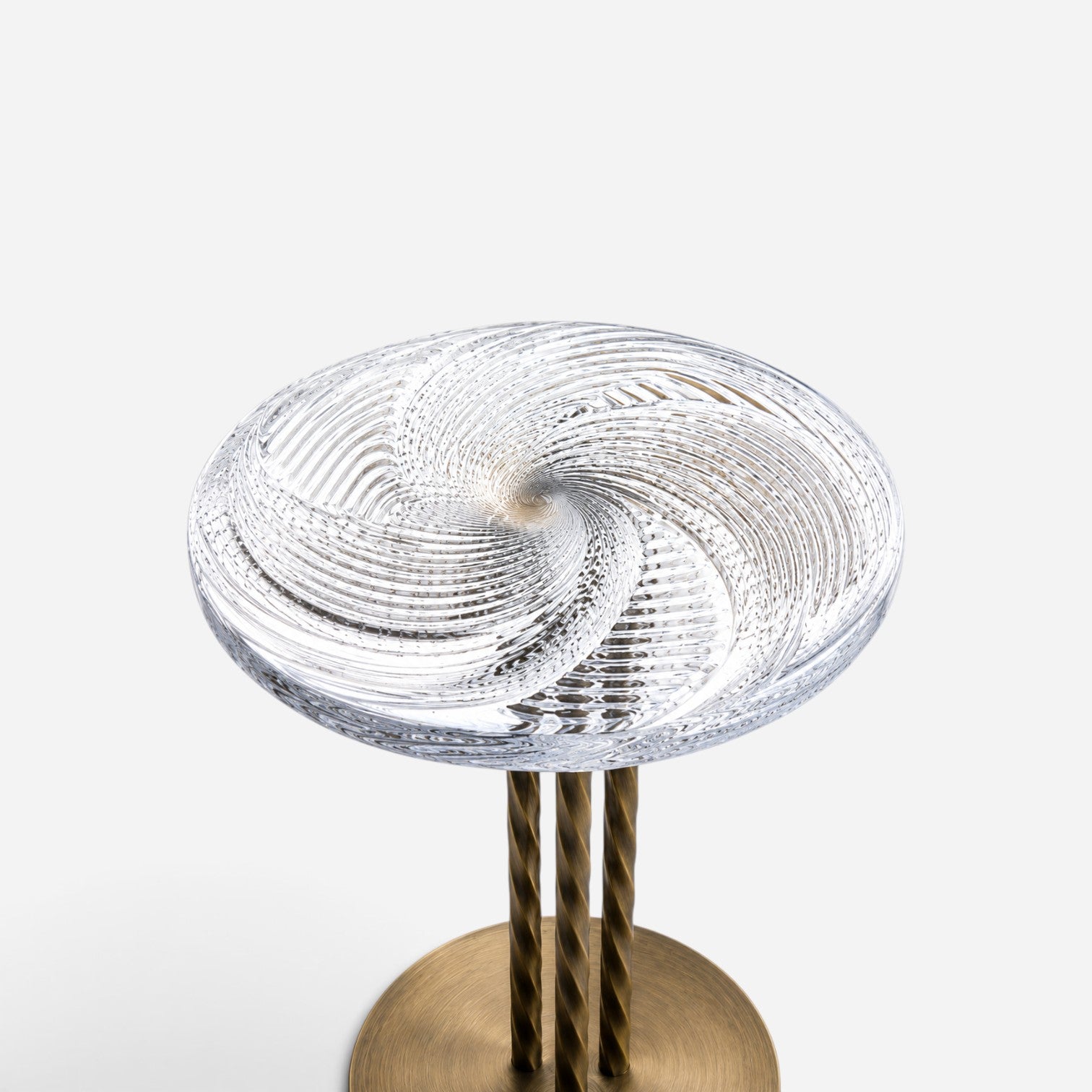 Addo Shop round side table with a clear glass swirl pattern top and three black twisted metal legs on a round base.