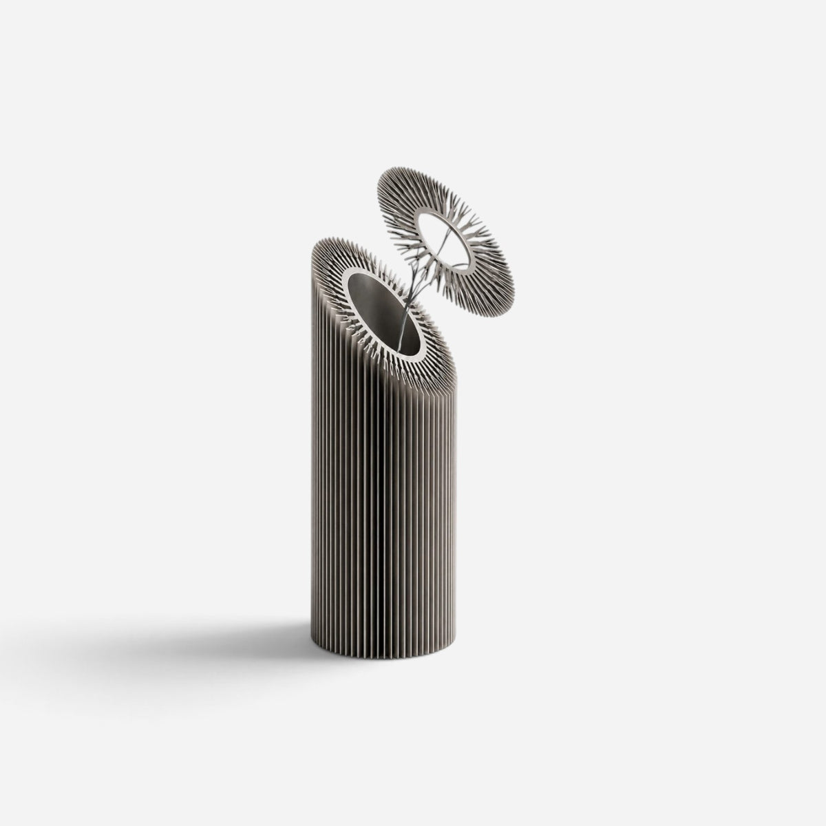 Addo Shop HELIO-1 sculptural design object made of brushed aluminum with a floral, industrial geometric form.