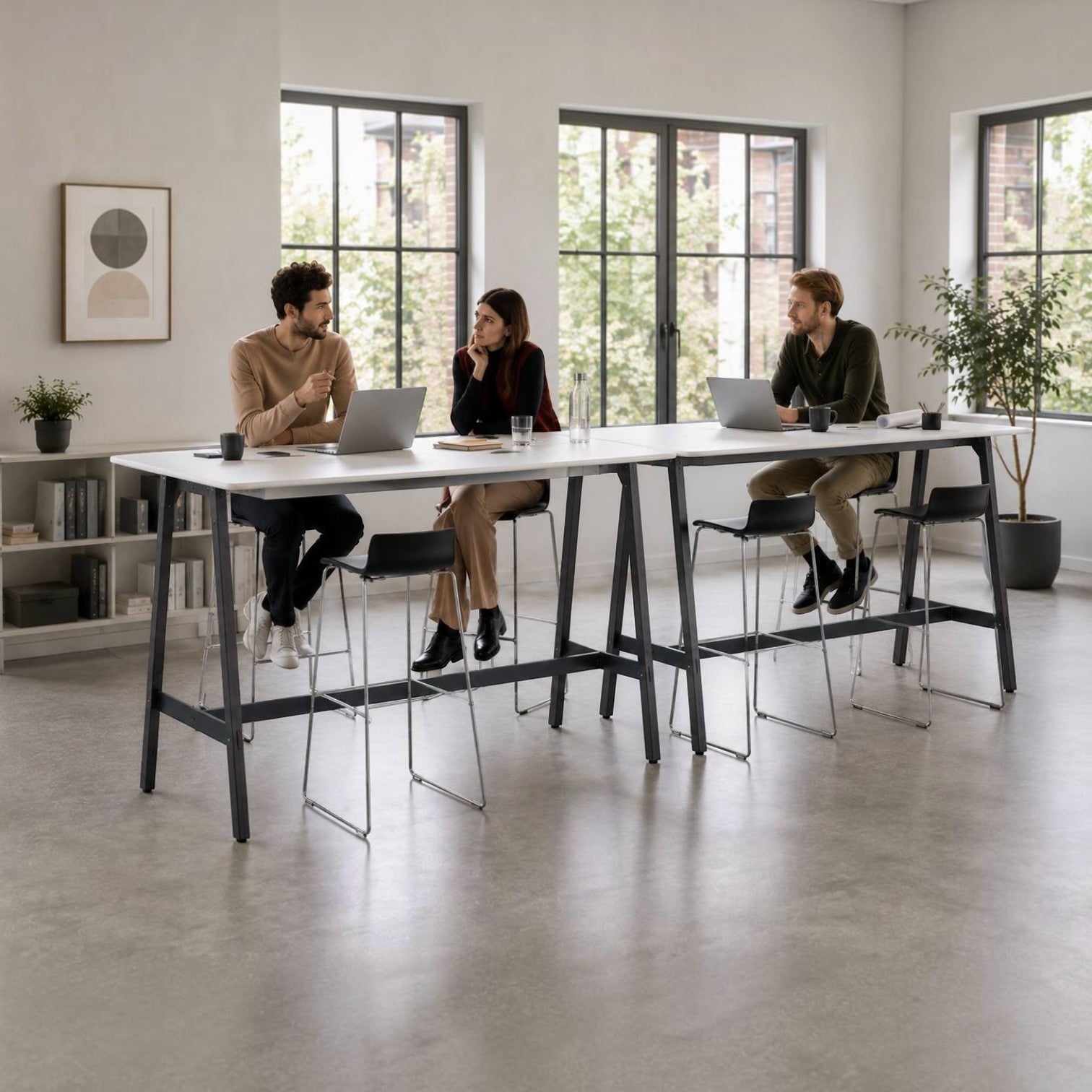 Addo Shop Hub W high desk in a modern office with three people collaborating on laptops while sitting on bar stools.