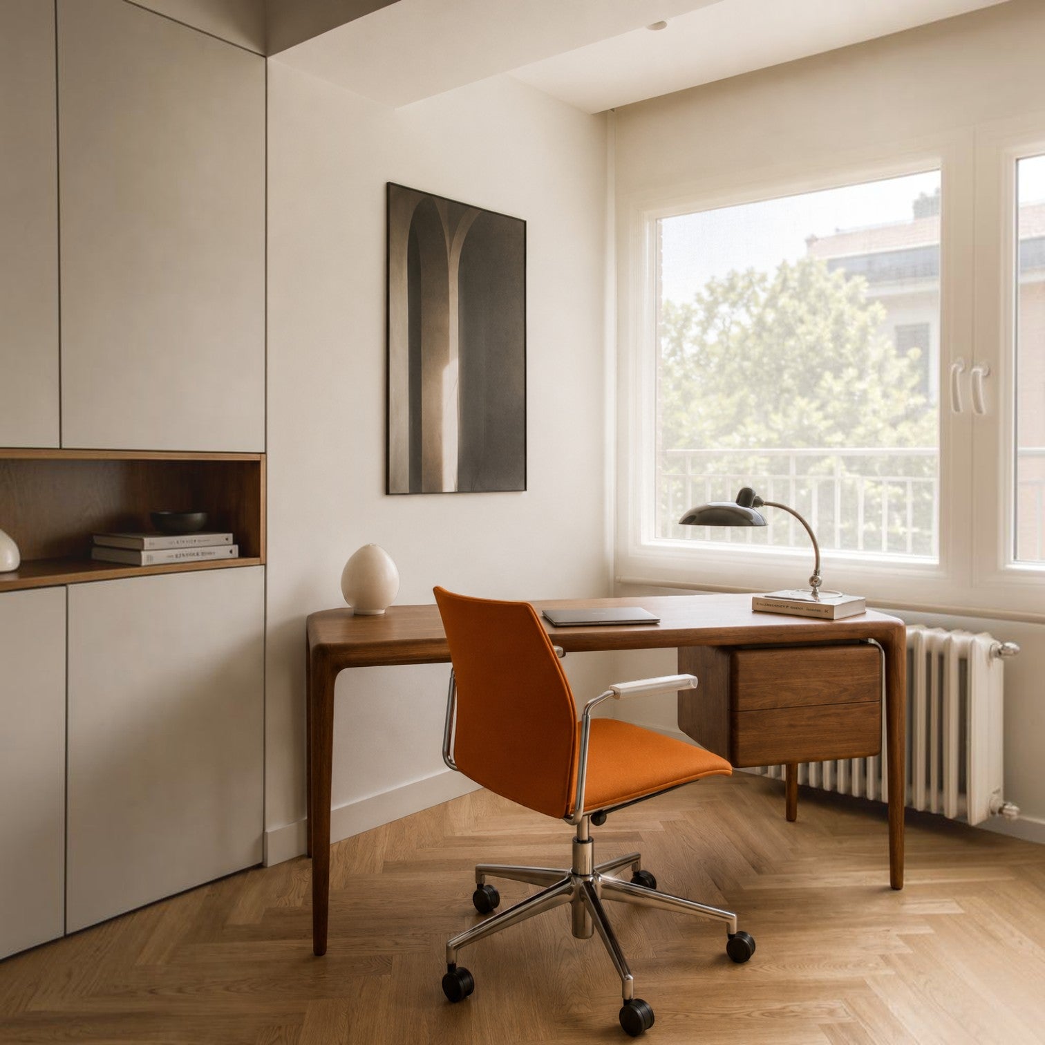 Addo Shop Incontro office chair with orange upholstery, white frame, and chrome base at a wooden desk in a home office.