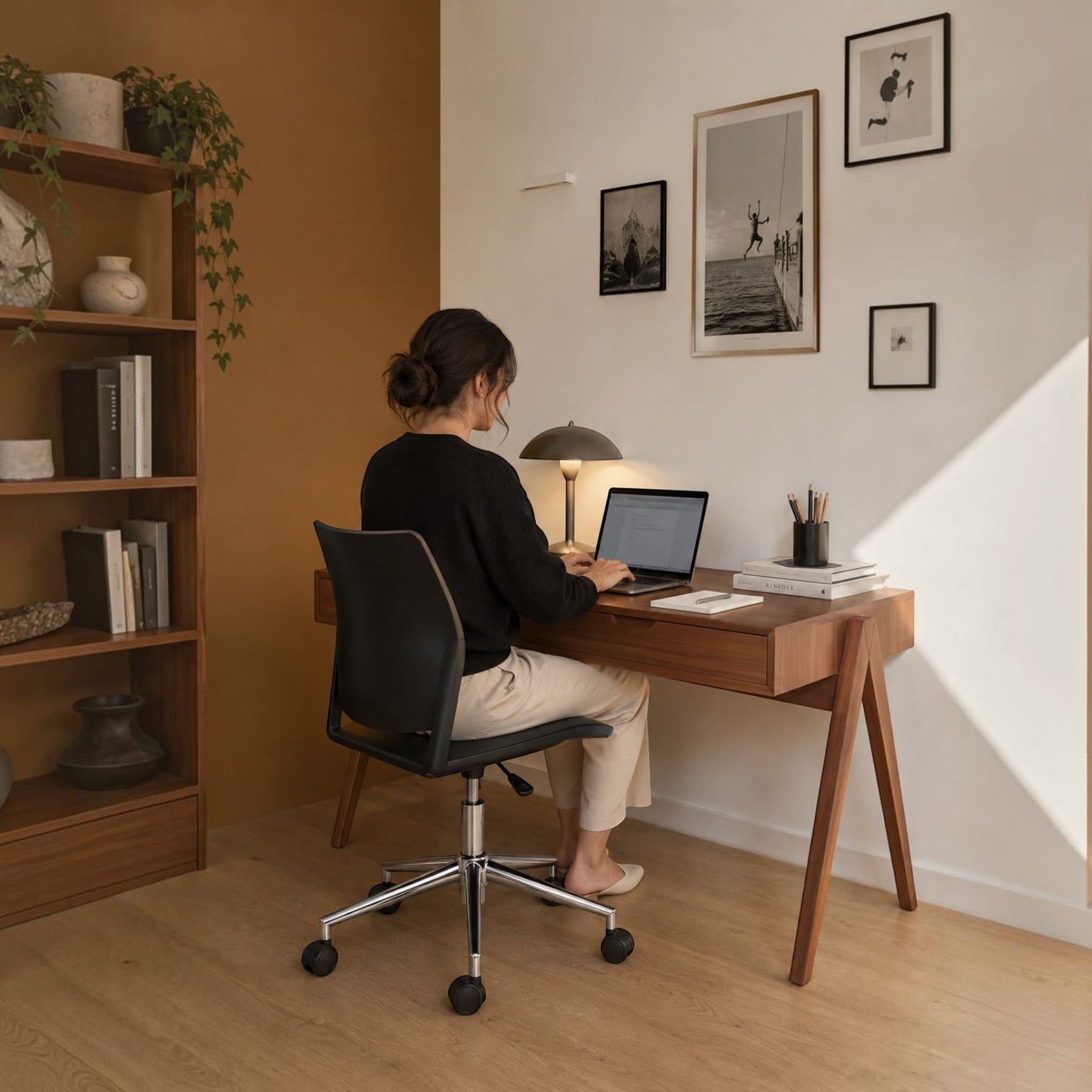 Addo Shop Incontro office chair with black frame and chrome base, used by a woman at a wooden desk in a home office.