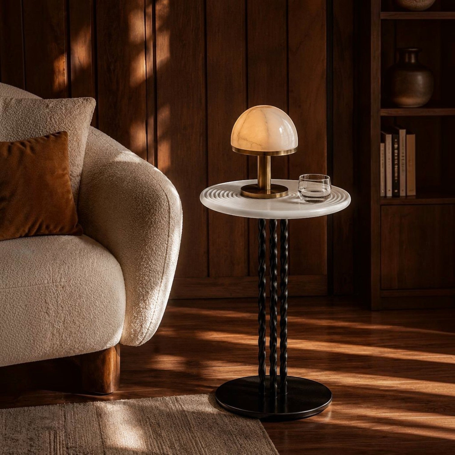 Addo Shop mushroom-style table lamp with a glowing marble shade and brass base on a white and black pedestal table