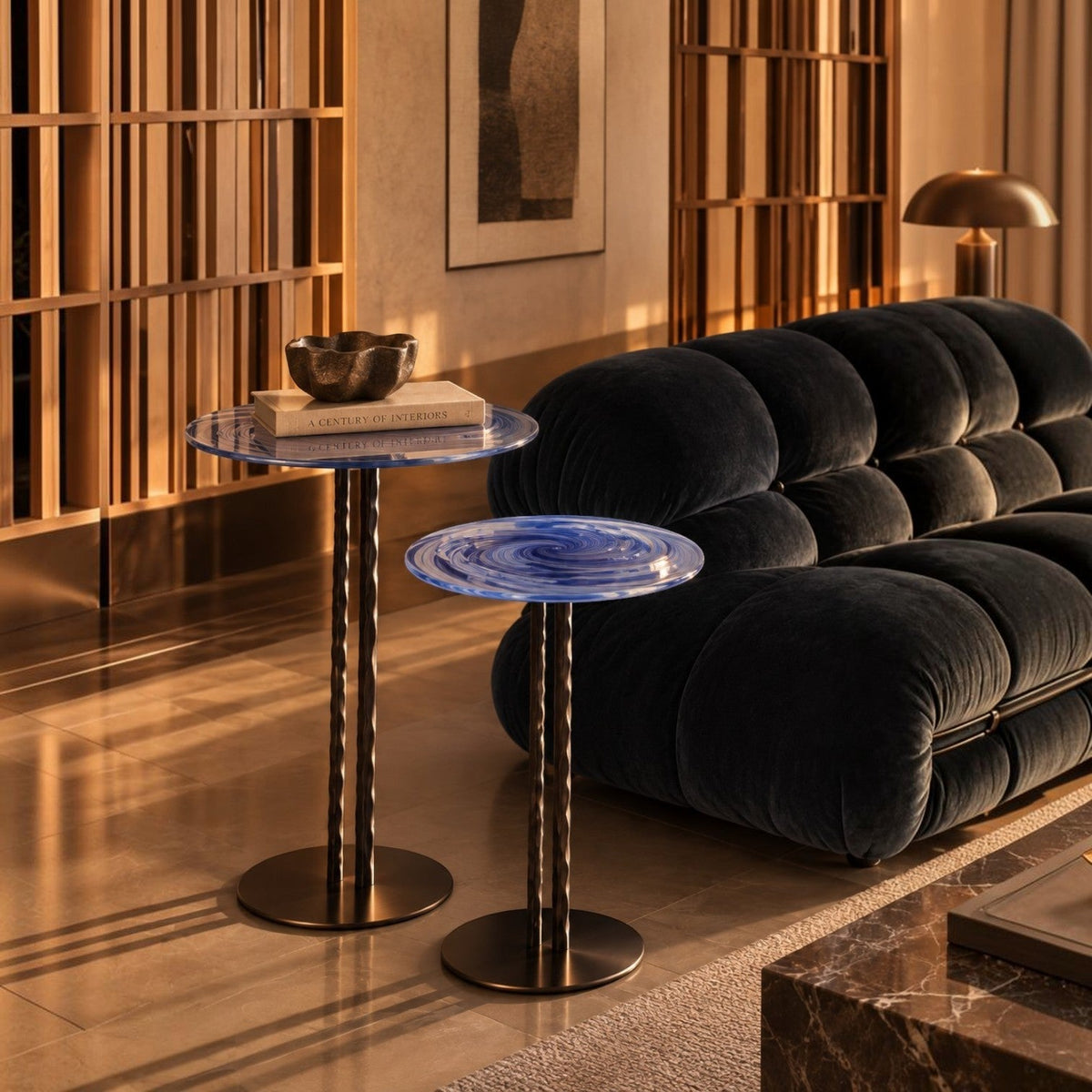 Addo Shop NAVIN duo side table set with blue swirl glass tops and metallic fluted pedestals in a modern living room.