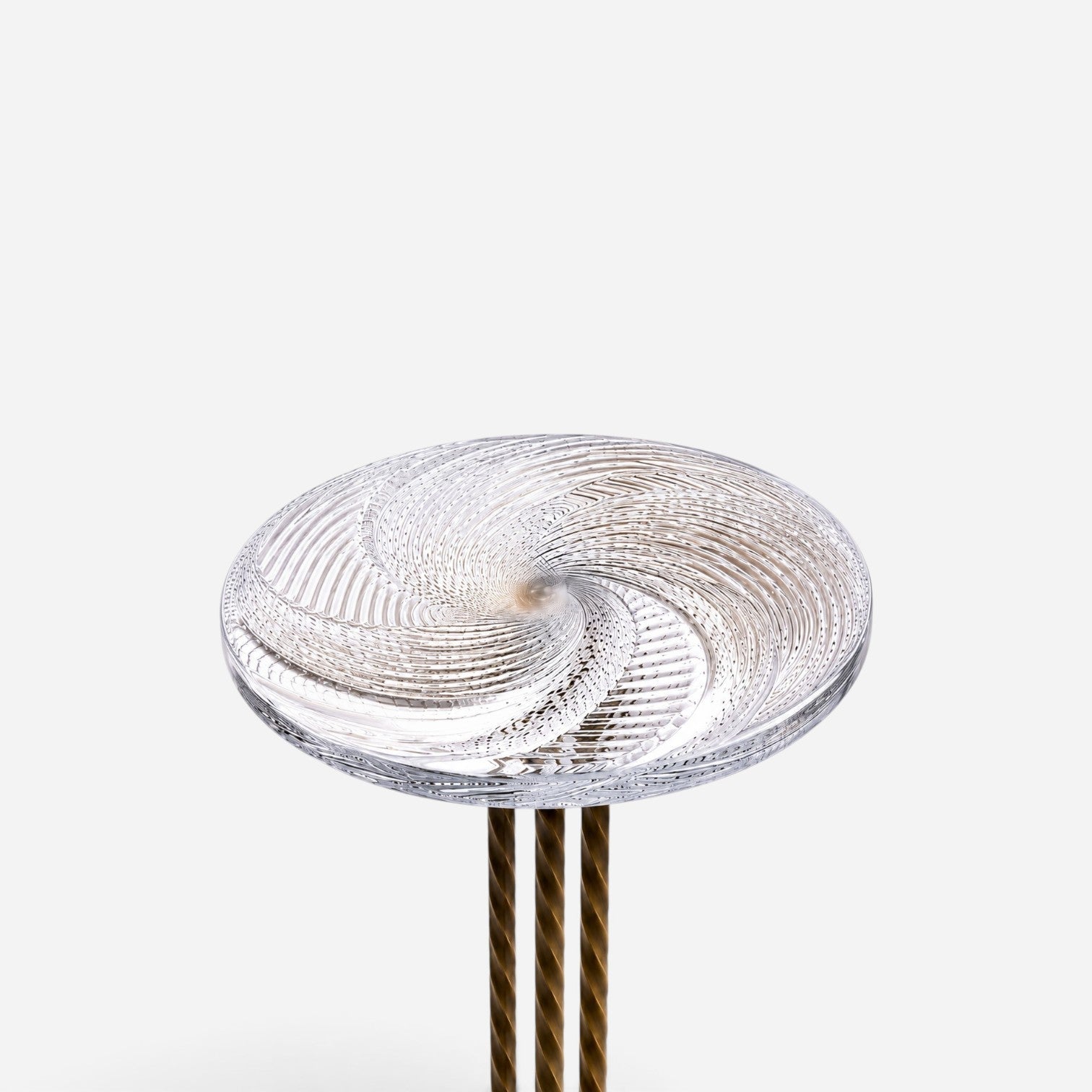 Addo Shop NAVIN Duo side table featuring a clear glass top with a swirling spiral pattern and metallic twisted legs.