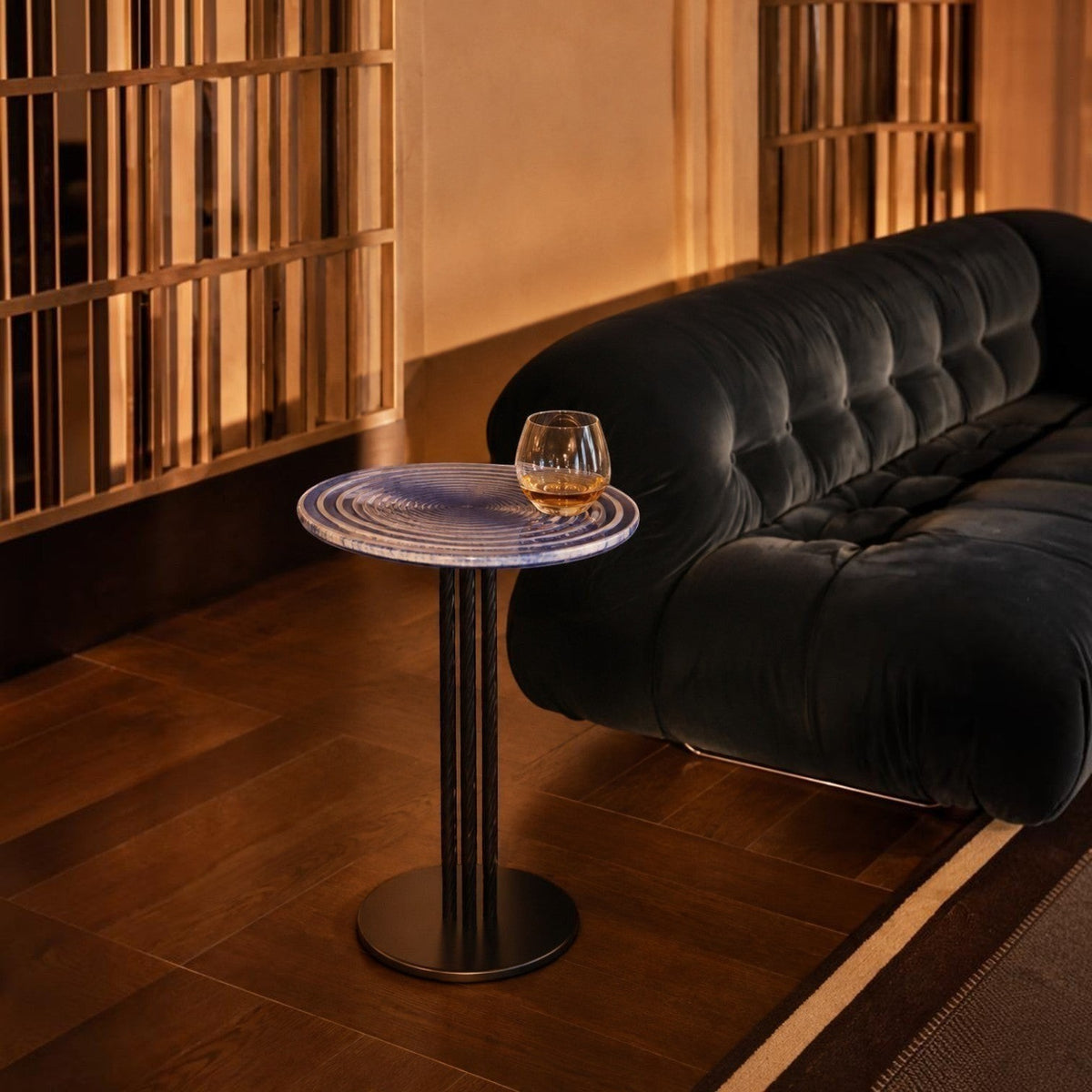 Addo Shop NAVIN low table with a blue Cesm-i Bulbul glass top and sculptural metal base in a warm living room setting.