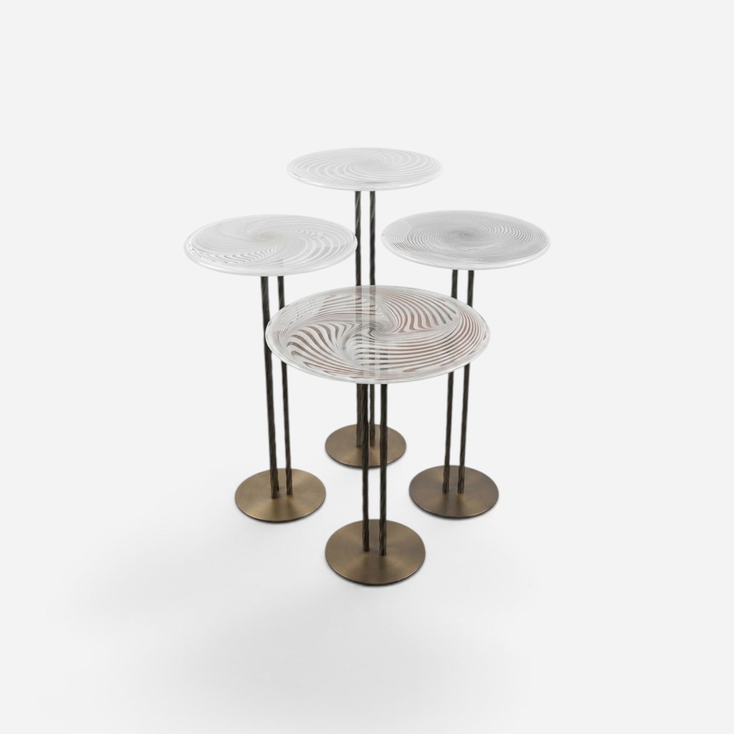 Addo Shop NAVIN quartet nesting table set with circular glass tops featuring a swirling pattern and bronze bases.