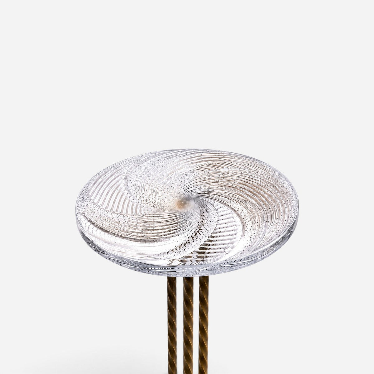 Addo Shop NAVIN trio side table featuring a clear glass top with a swirling spiral pattern and metallic twisted legs.