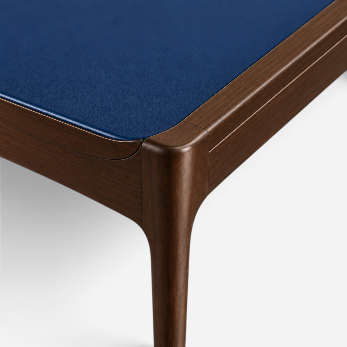 Addo Shop ODAK RAY desk corner featuring dark wood grain legs and a smooth navy blue leather desktop surface