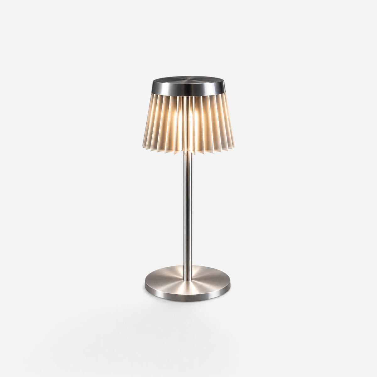 Addo Shop Piliseli table lamp in brushed aluminum with a pleated shade design that creates a soft, warm glow.