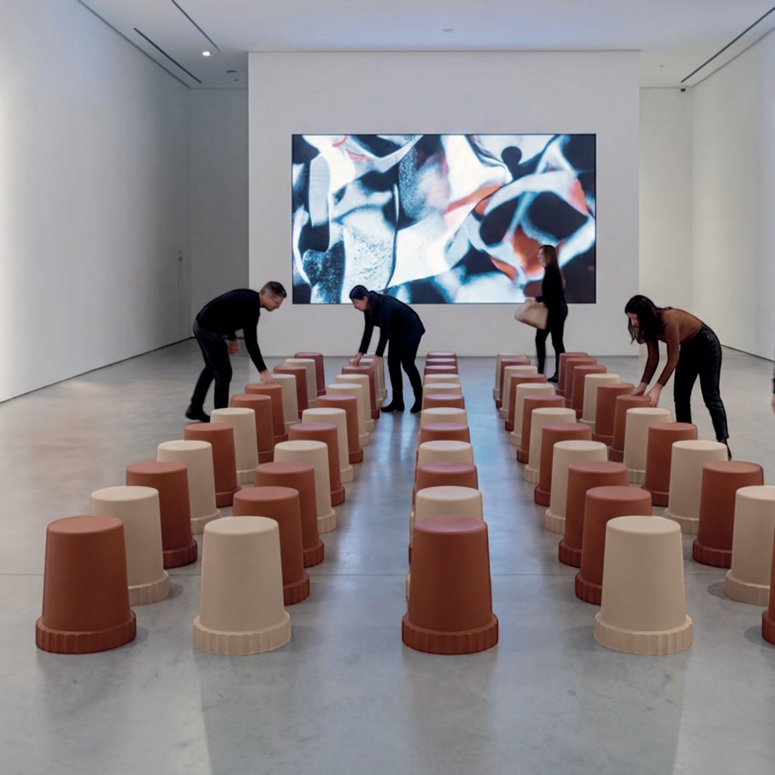 Addo Shop Raffles System Stools in terracotta and cream arranged in rows within a modern gallery space.