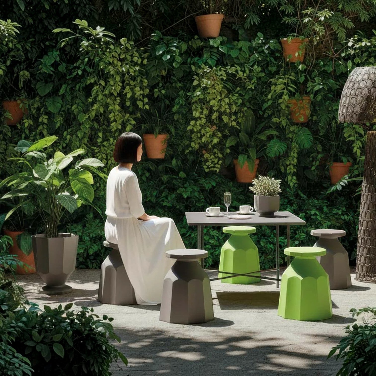 Addo Shop Rerecycled Stool in green and grey, featuring a geometric faceted design in a lush garden setting.