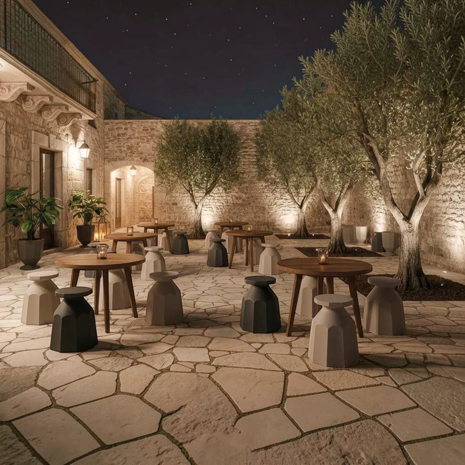 Addo Shop Rerecycled Stool in black and white, featuring a faceted design in a rustic outdoor stone courtyard setting.