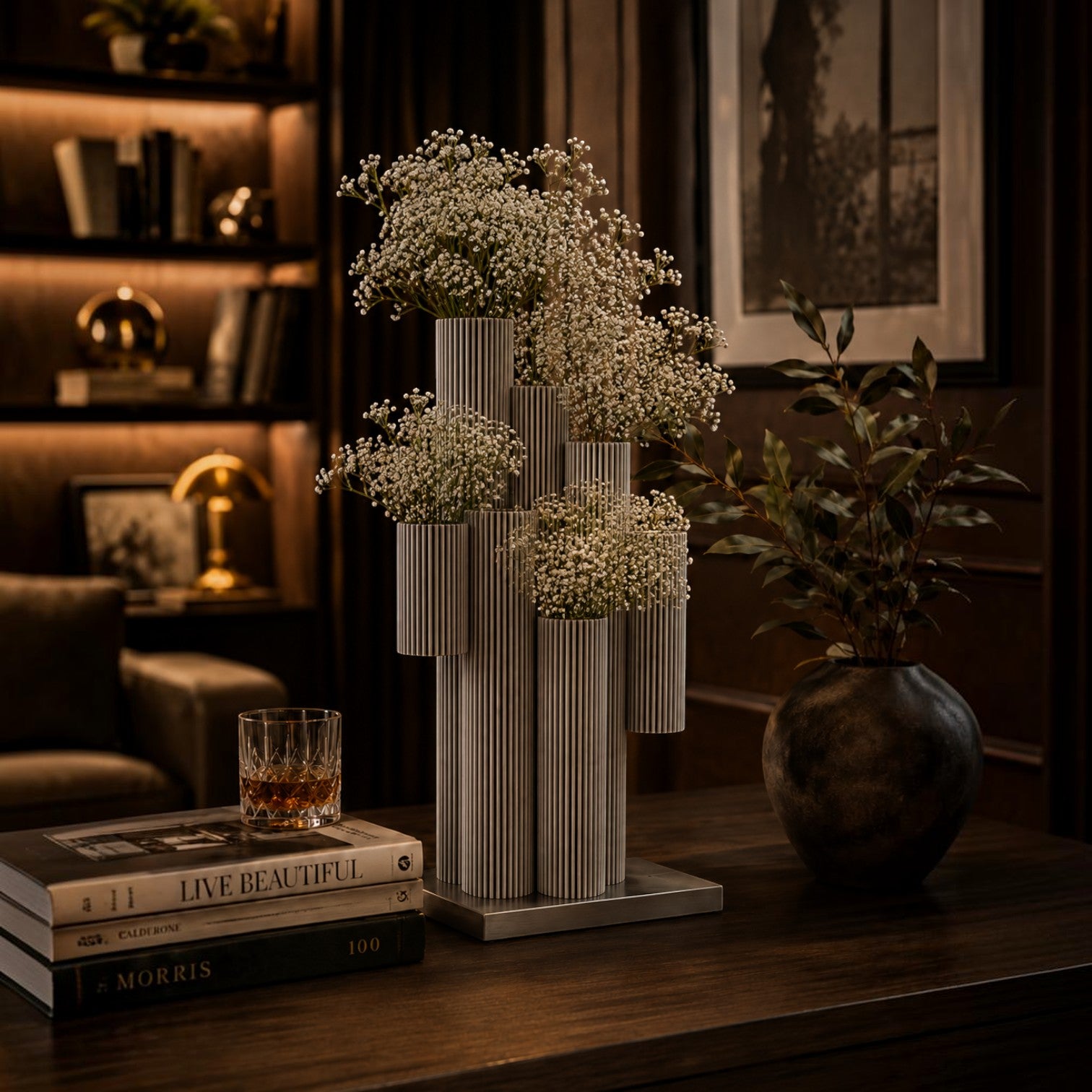 Addo Shop modern grey ribbed multi-tube ceramic vase filled with white baby's breath flowers on a wooden table.