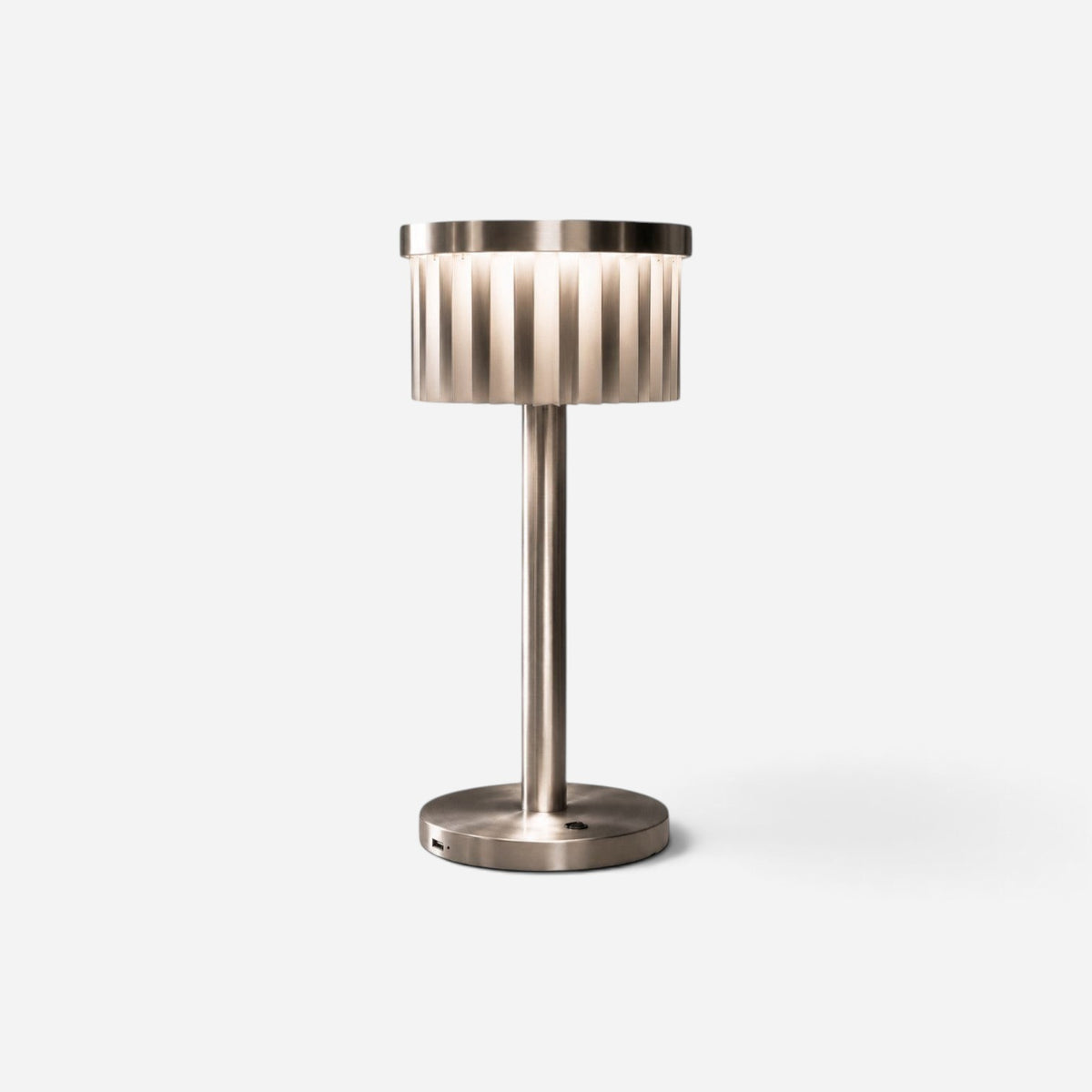 Addo Shop ŞEMS-1 brushed aluminum table lamp with a cylindrical fluted shade providing soft ambient lighting.
