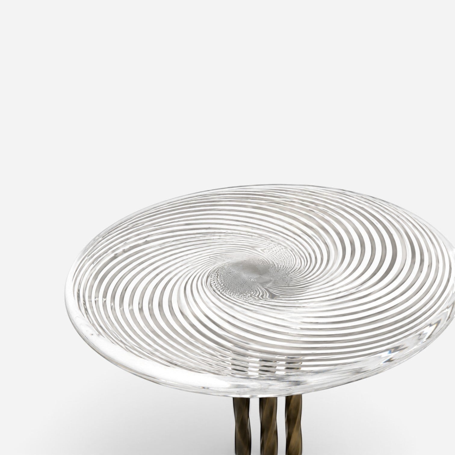 Addo Shop side table with a clear circular glass top featuring a swirling spiral pattern and twisted metal base