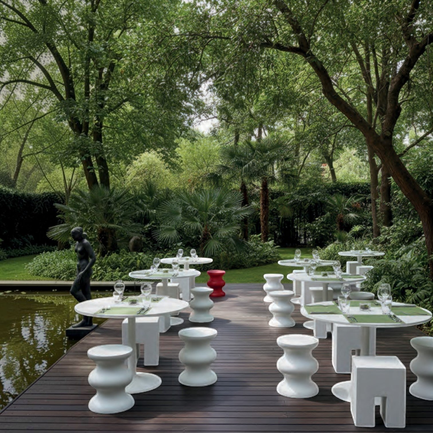 Addo Shop STILEMI Cube white modern sculptural stool on a wooden patio in a lush garden setting