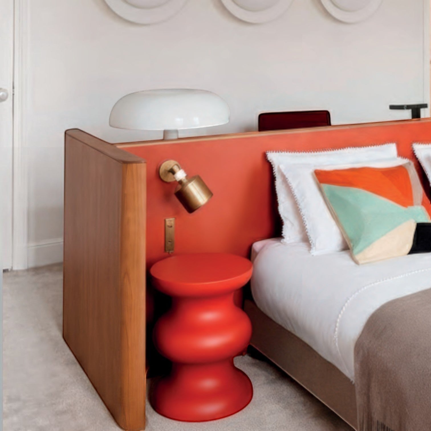 Addo Shop STILEMI Sculptural red side table with a rounded, stacked design in a modern bedroom setting.