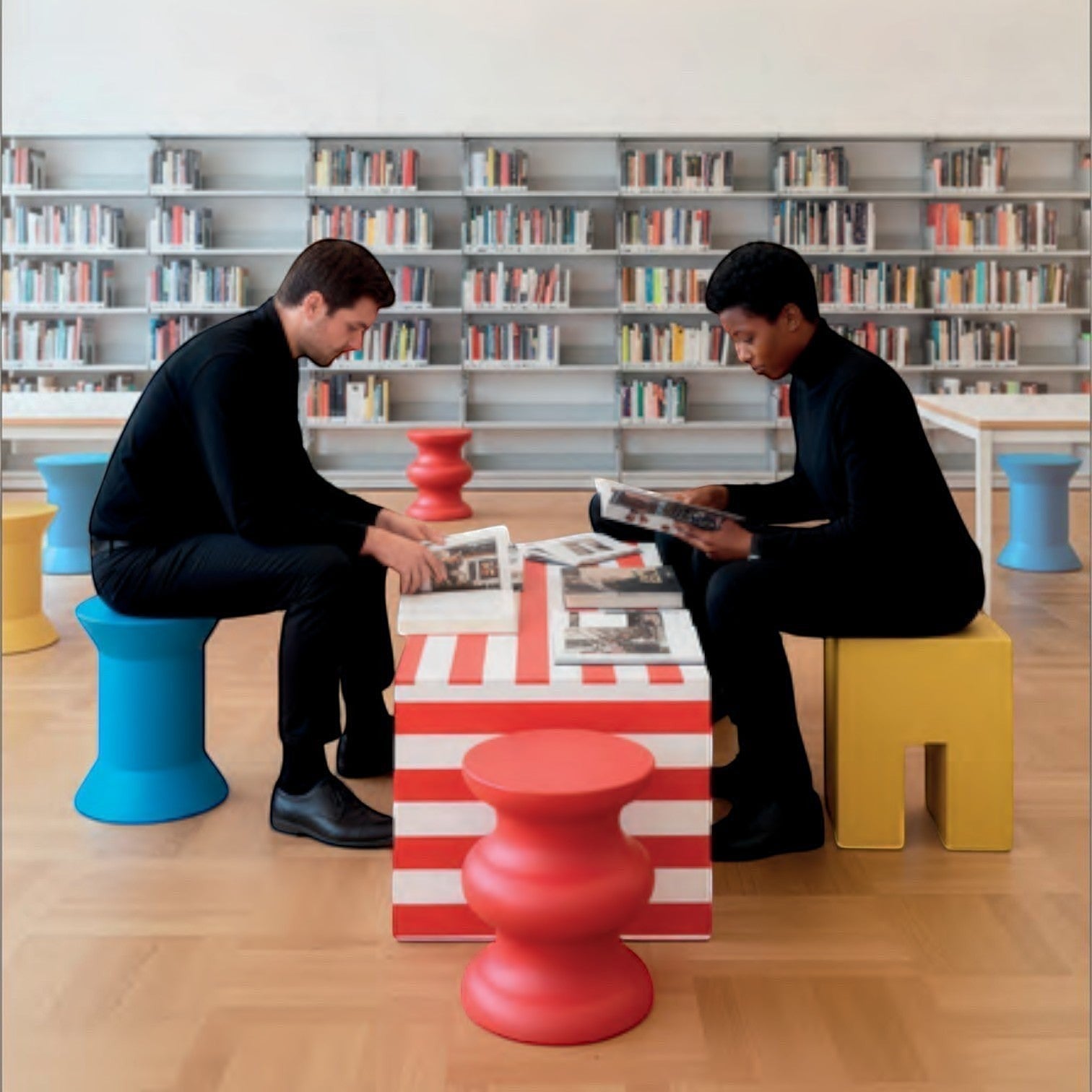 Addo Shop STILEMI Sculptural stools in vibrant red, blue, and yellow arranged in a modern library setting.