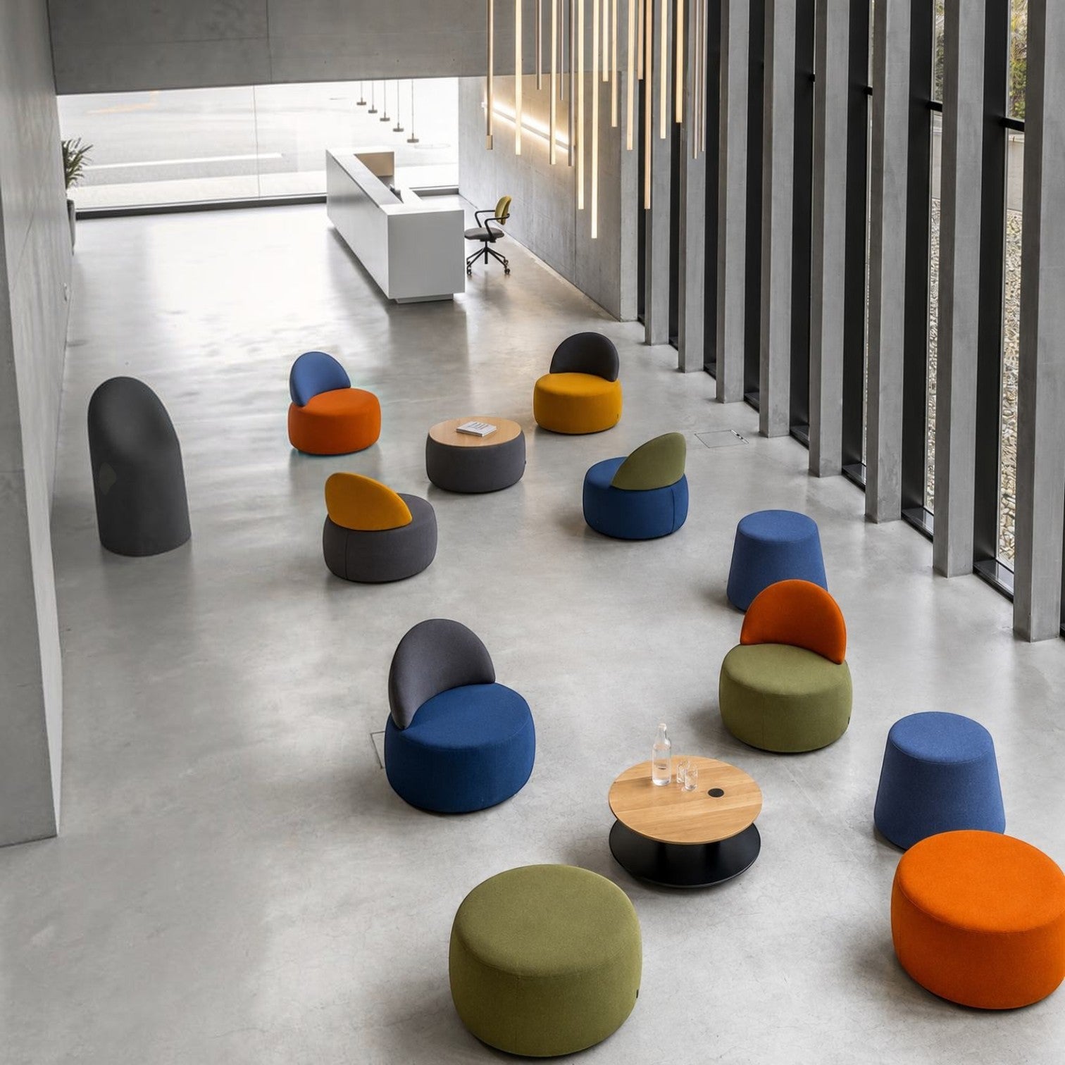Addo Shop Swap Puf Trapez collection featuring colorful upholstered poufs in a modern office lounge area