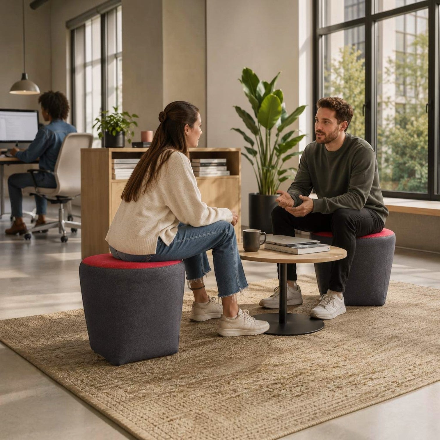 Addo Shop Swap Puf Trapez two-tone upholstered poufs in grey and red, used in a modern office breakout area.