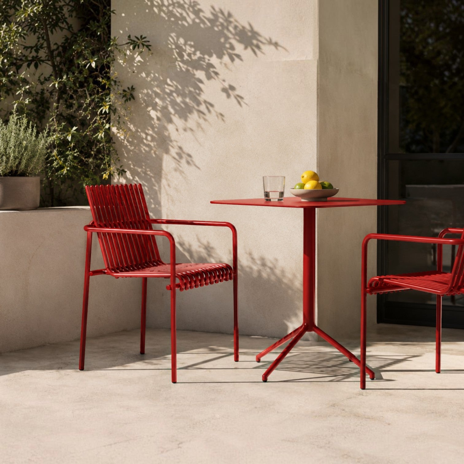 Addo Shop Zeroquindici .015 Amalfi red metal outdoor chair with slatted seat and arms on a sunny patio.