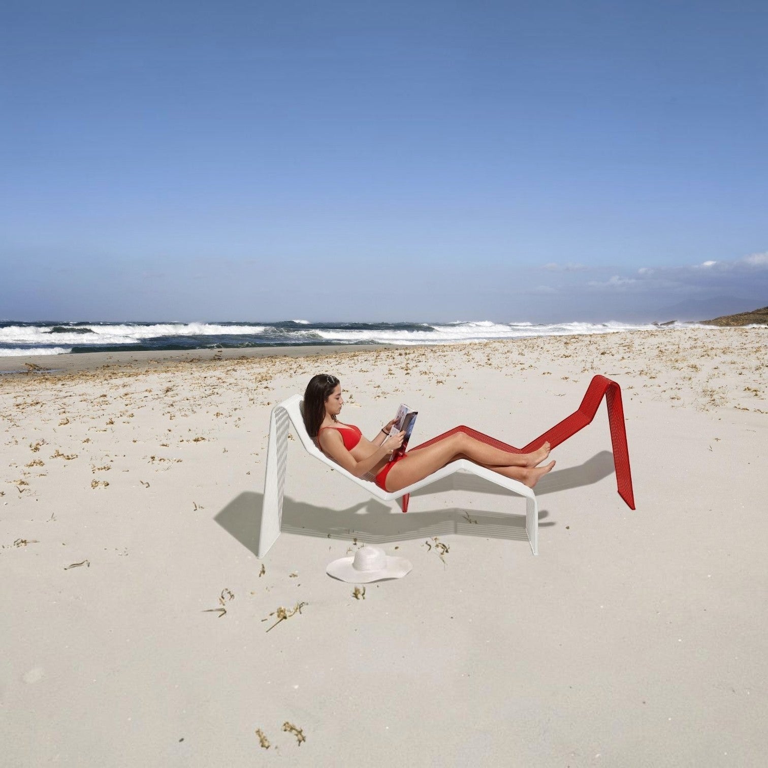 Woman reading on a white Zeroquindici .015 Chaise Longue by Addo Shop on a sunny beach with a red chair nearby.