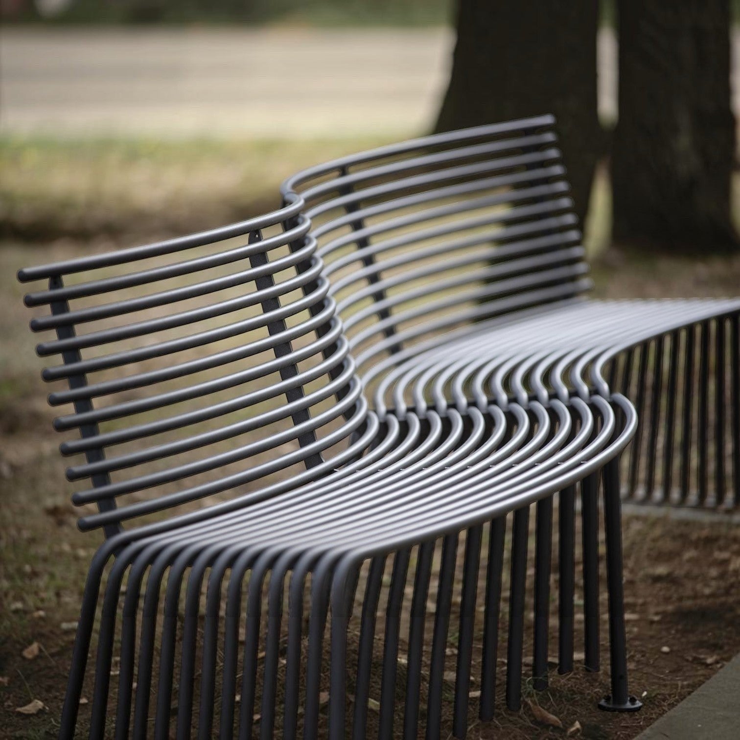 Addo Shop Zeroquindici .015 convex outdoor bench with backrest in grey metal featuring a modern slatted design.