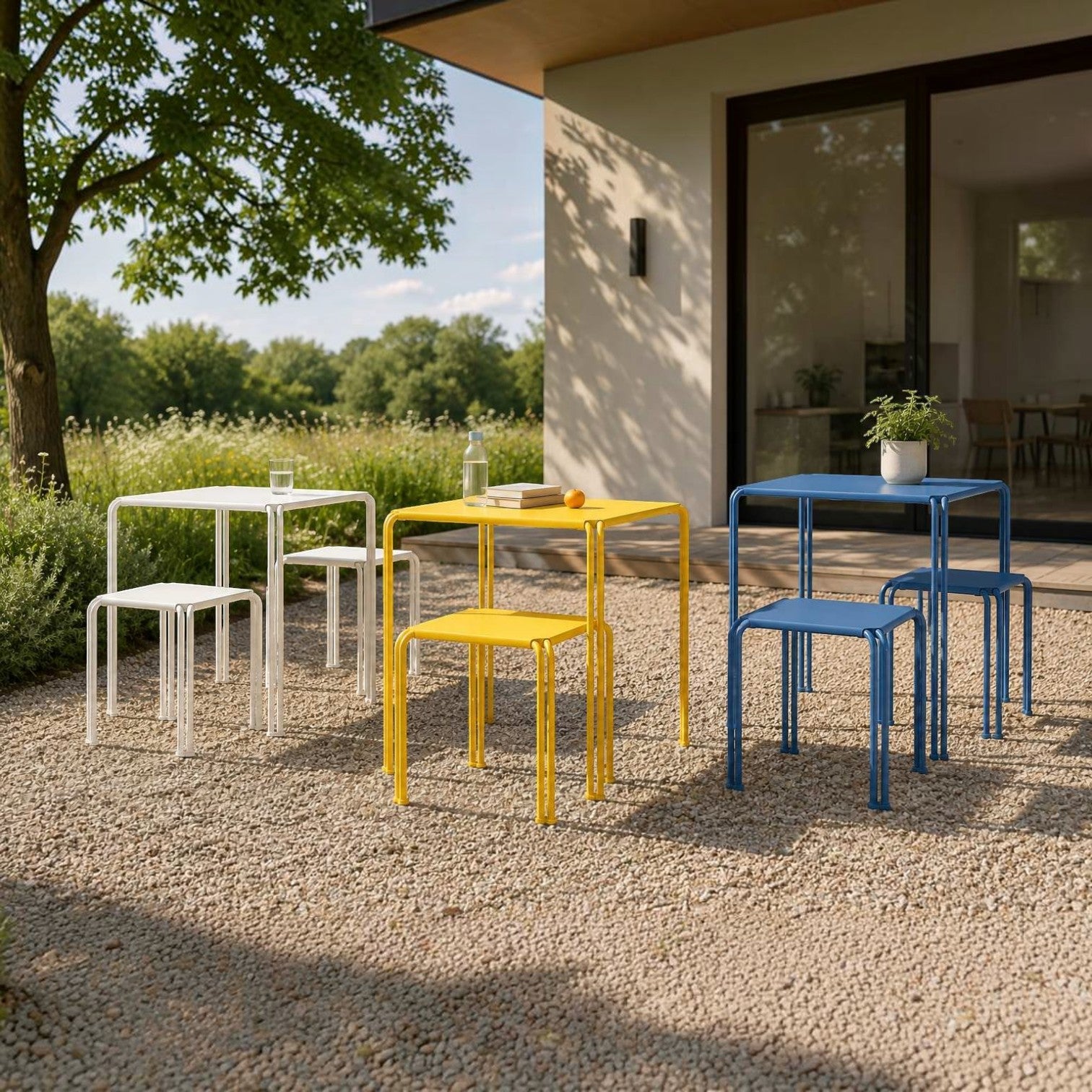 Addo Shop Zeroquindici .015 metal school tables and stools in white, yellow, and blue on a gravel patio.
