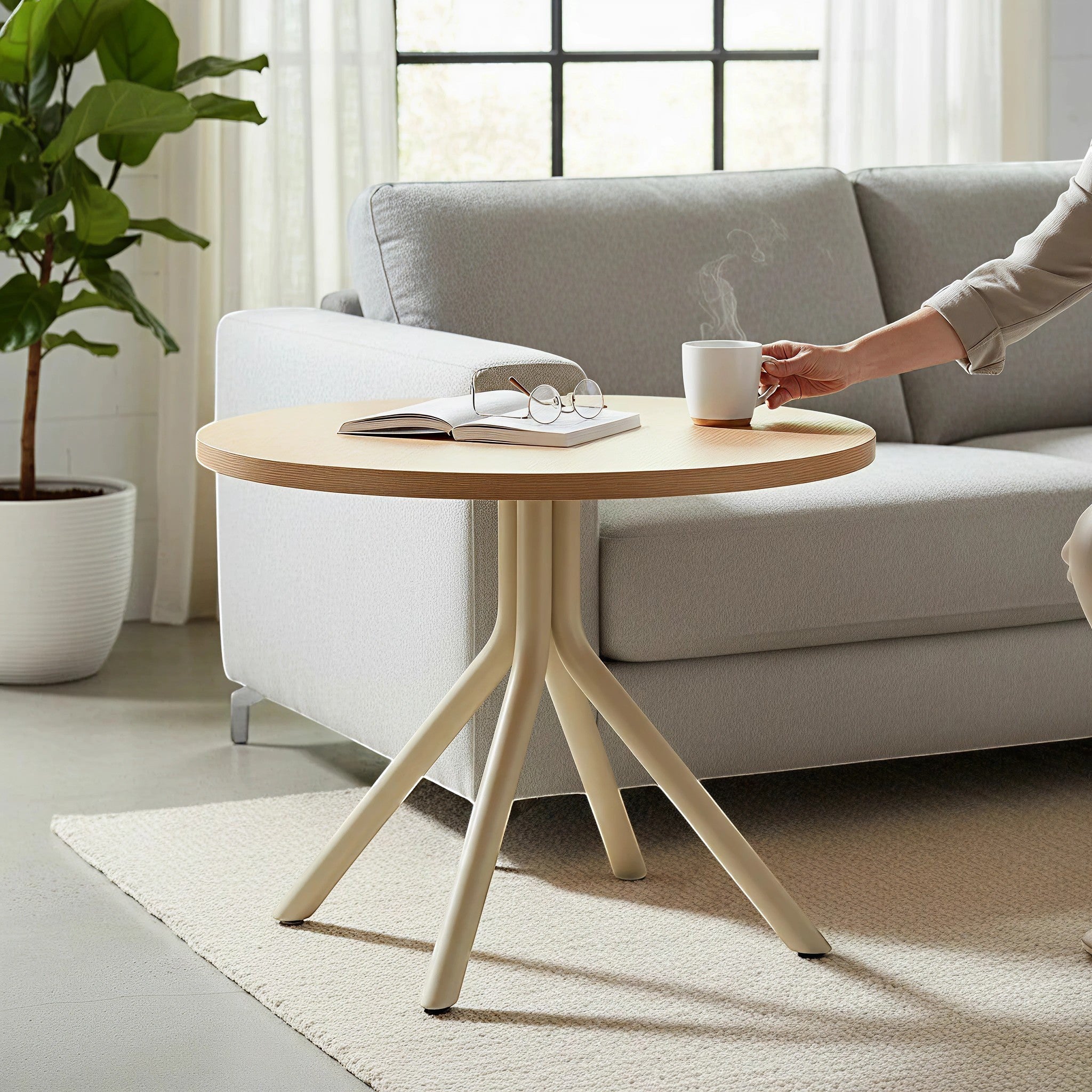 Addo Shop Bob Round Wood Side Table with light wood top and cream legs, next to a sofa.