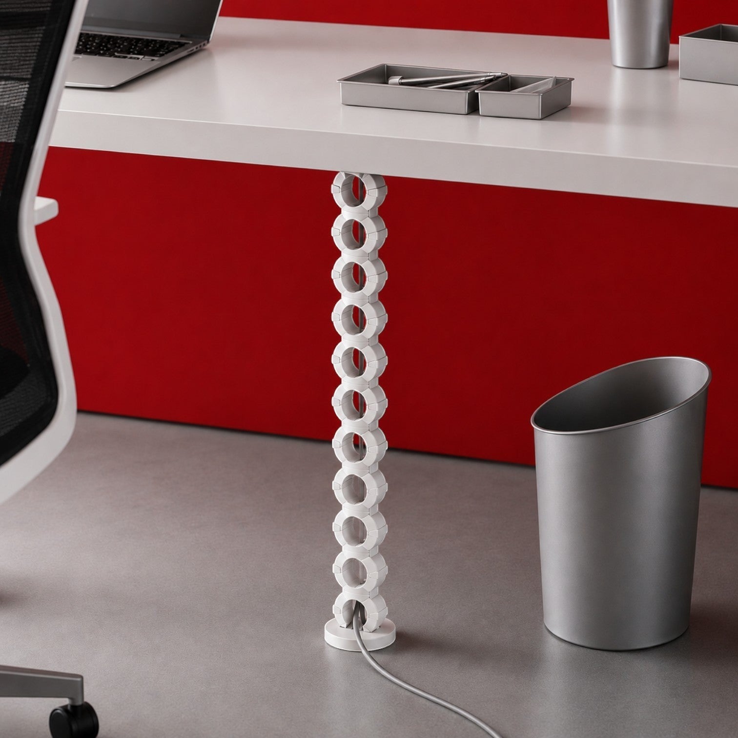 Addo Shop white modular cable holder with circular links, attached under a desk to manage cords.