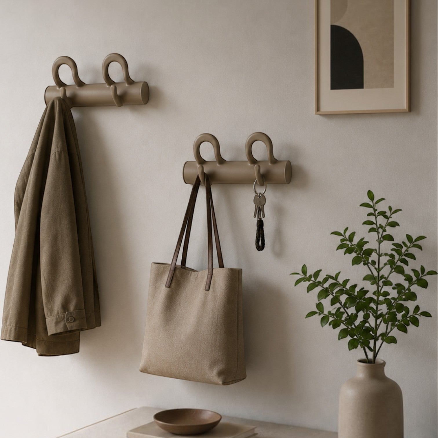 Addo Shop Duo wall hooks in beige holding a jacket and tote bag. Modern entryway decor.
