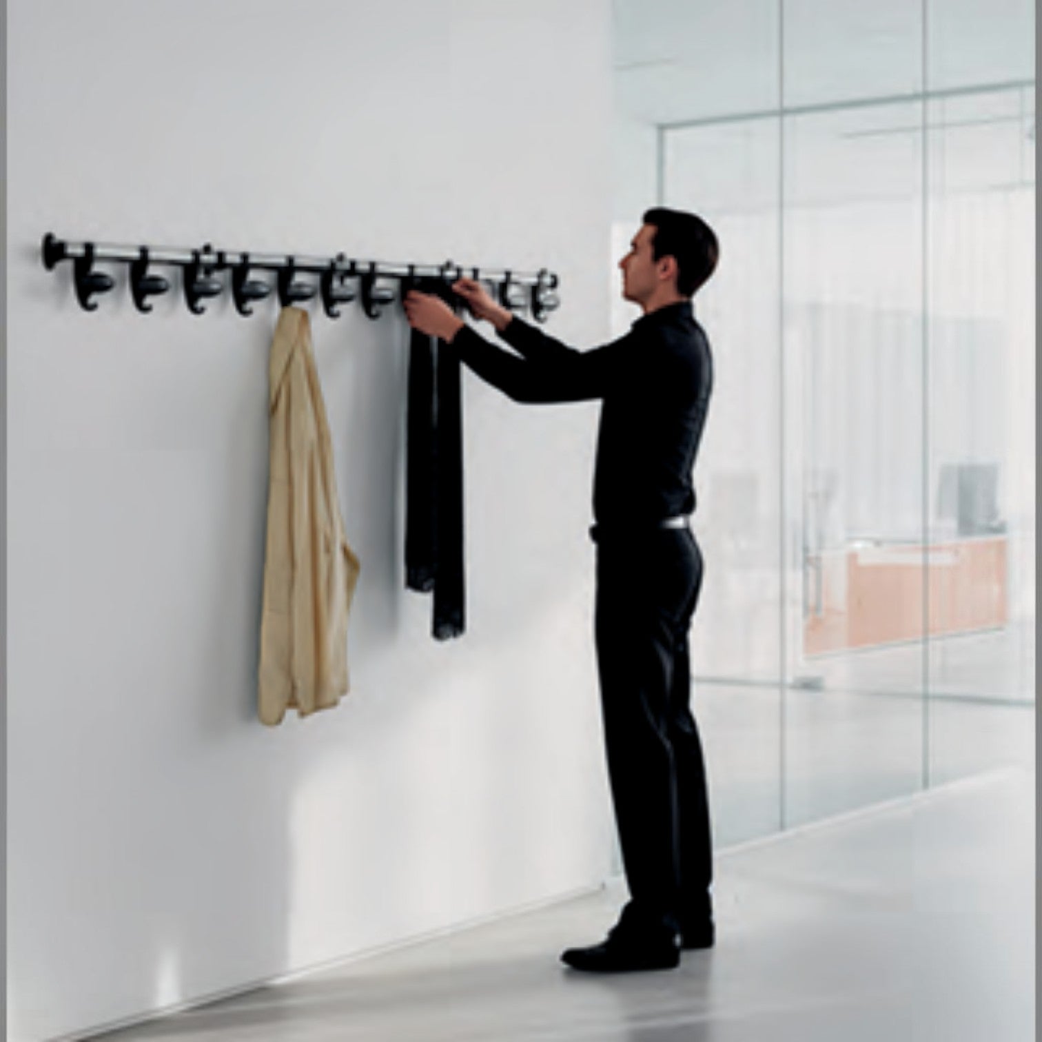 Addo Shop Hook coat rack with multiple hooks, a man is hanging a scarf on it. Modern design for office or home.