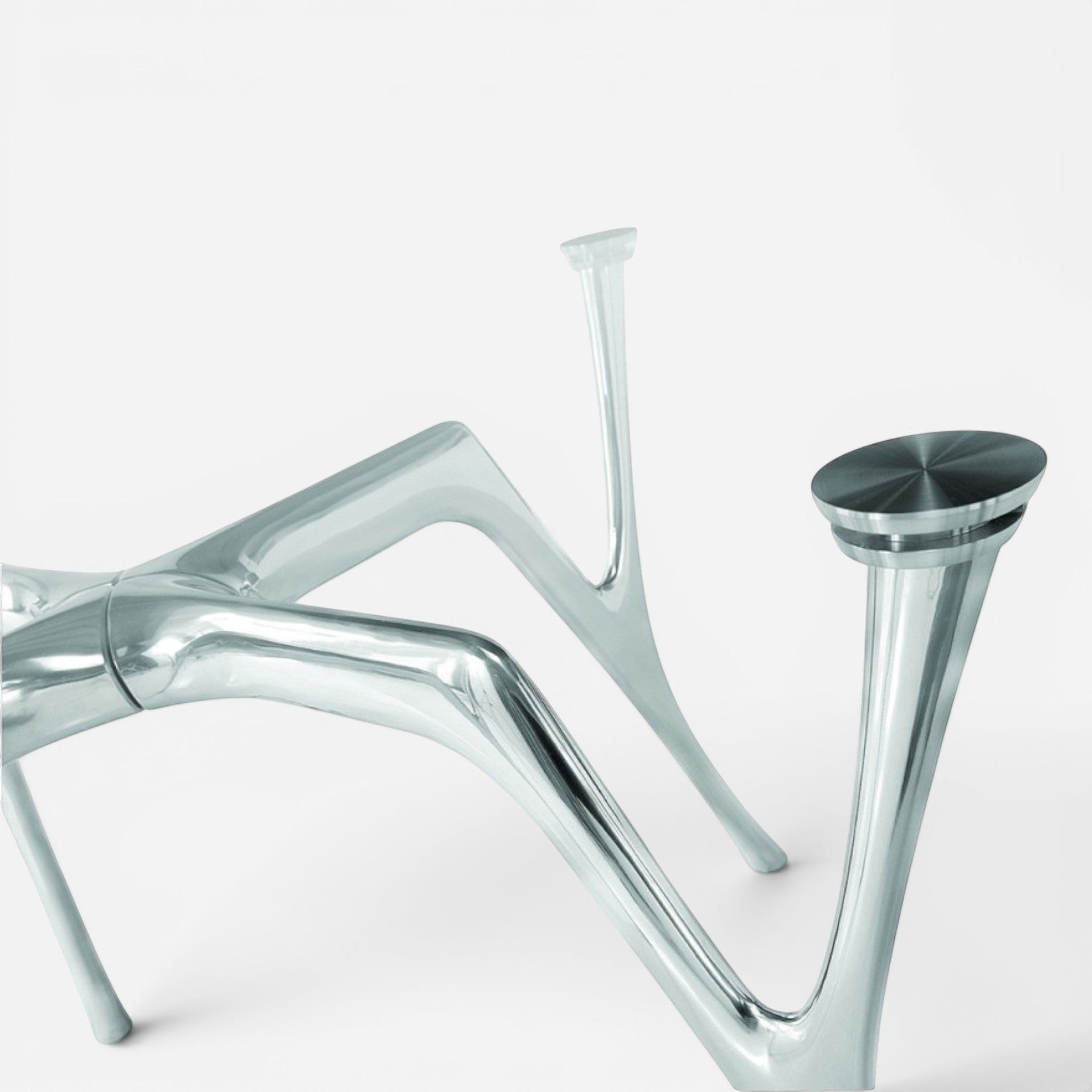 Addo Shop Pegaso glass top dining table with unique sculptural polished metal legs.