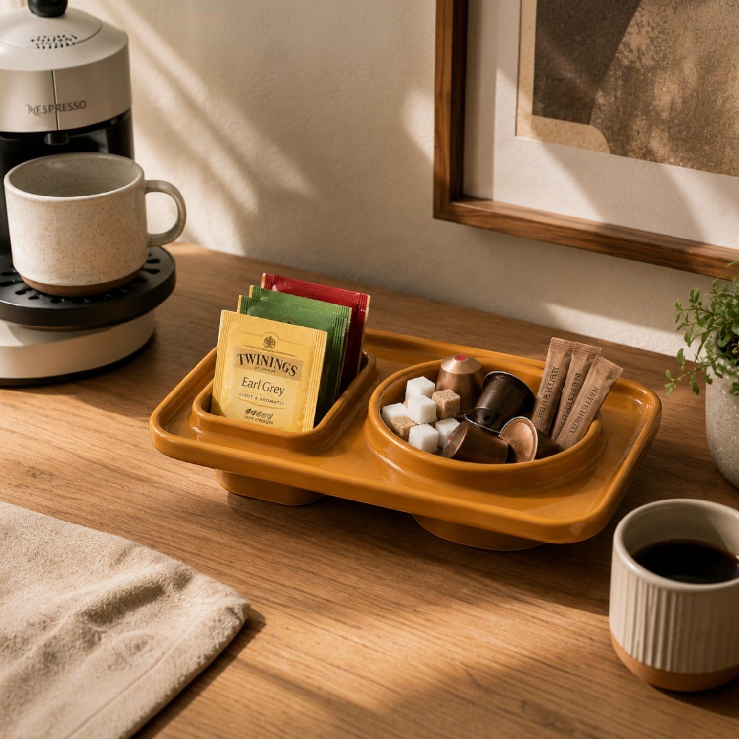 Addo Shop PLAT multifunctional tray in mustard yellow, holding tea bags, sugar cubes, and coffee capsules.