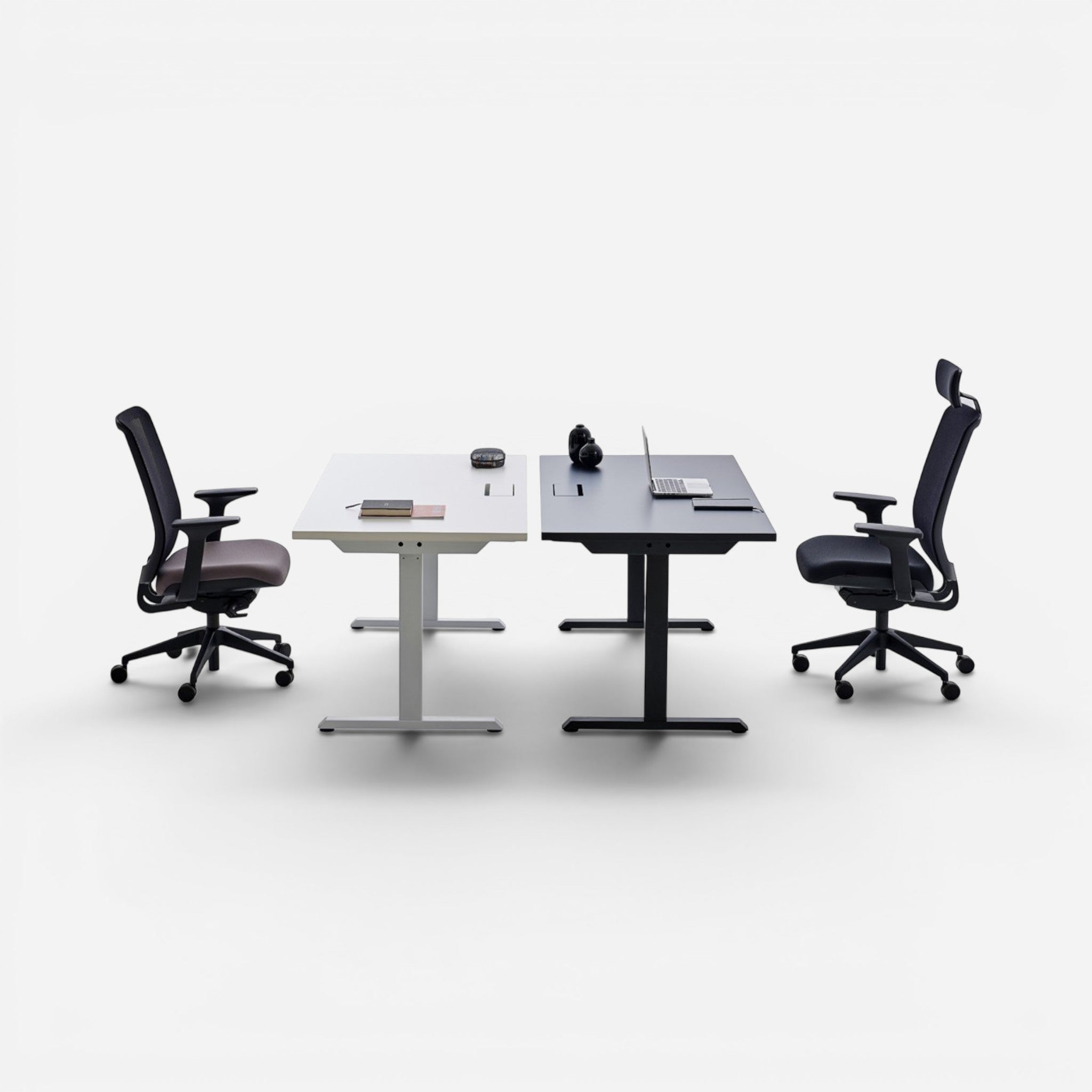 Addo Shop Up Down sit-stand desks in white and black with ergonomic chairs. Height adjustable.