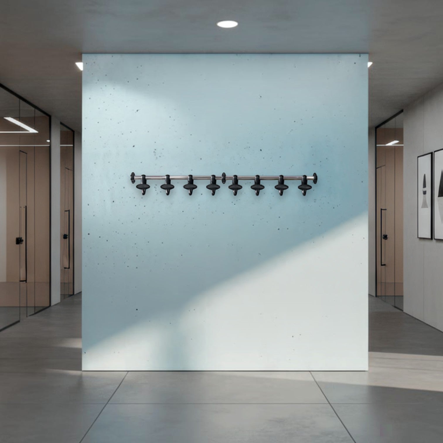 Addo Shop wall-mounted coat rack with 8 black hooks on a silver bar, mounted on a light blue wall.