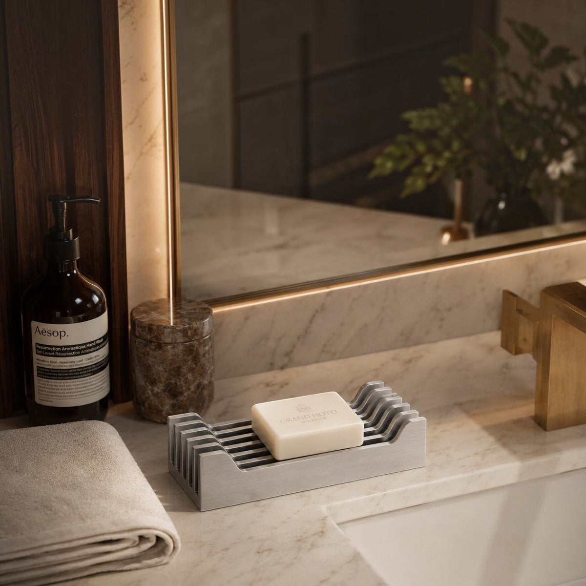ARİ sabunluk, mermer banyo tezgahında sabun, sıvı sabun şişesi ve havluyla aynalı banyo ortamında