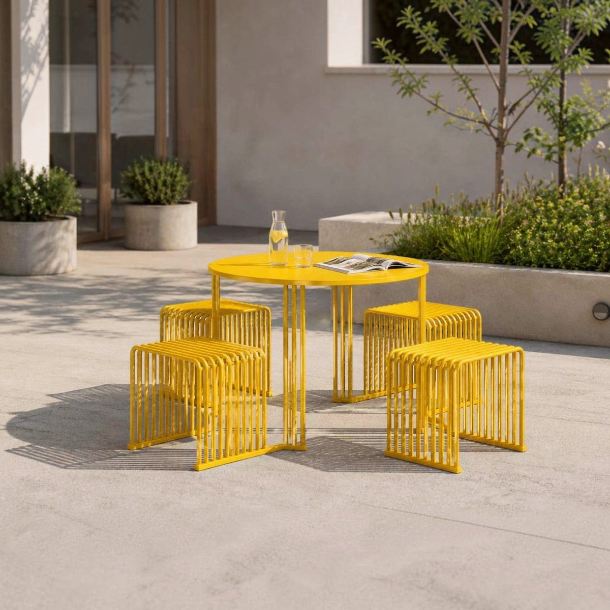 DIEMMEBI Zeroquindici .015 Octopus piknik masası, sarı model beton zeminli avluda, üzerinde sürahi ve dergi
